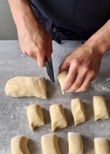 Buns sans gluten au zeste d’orange - Divise la pâte en 15 morceaux égaux, d’environ 70 g chacun, ou fais dix gros pains, d’environ 110 g chacun.