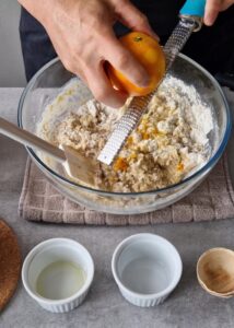 Buns sans gluten au zeste d’orange - Mélange les liquides (lait d’avoine, œufs battus, huile d’olive et levure dissoute). Mélange partiellement la pâte, puis ajoute le zeste d’orange et le vinaigre de cidre.