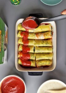 Cannelloni sans gluten aux épinards et crème fraîche - Verse la sauce béchamel et le reste de la sauce tomate sur les cannellonis.