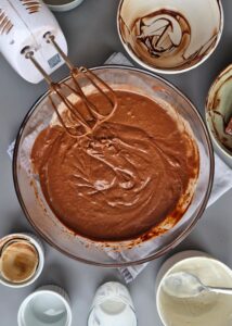 Cheesecake basque chocolat sans gluten allégé - Fouette dans un grand saladier le sel, les œufs, le sucre, le cacao en poudre, la poudre de vanille et le fromage frais sans produits laitiers jusqu’à obtenir une texture lisse et crémeuse.