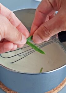Clafoutis sans gluten à l’abricot et au romarin - Fais chauffer le lait d’avoine, la crème entière sans lactose, le sucre et la branche de romarin dans une petite casserole à feu doux jusqu’à frémissement.