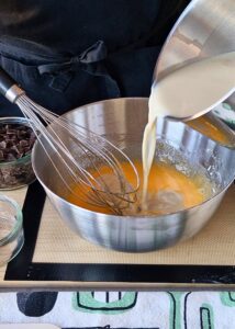 Crème pâtissière au chocolat sans lactose (sans gluten) - Verse lentement ⅓ du lait d’avoine chaud dans le mélange aux œufs en fouettant constamment pour le tempérer.