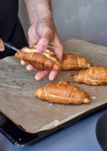 Croissant aux amandes sans gluten à la confiture de fruits rouges - Coupe les croissants dans la longueur avec un couteau à pain. Humidifie-les en badigeonnant les croissants coupés avec le sirop à la vanille.