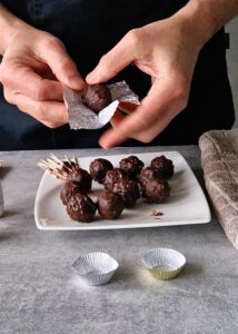 Ferrero Rocher sans gluten : comment en faire - Emballe chaque chocolat avec une feuille de papier aluminium doré ou argenté de 8,5 x 8,5 cm, puis place-le dans une petite caissette dorée pour truffe au chocolat.