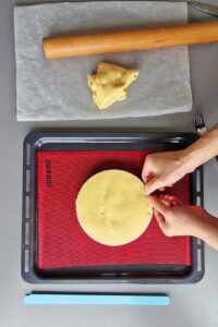 Flan sans gluten aux agrumes - Transfère la pâte dans un moule à tarte ou un cercle à tarte à l’aide d’un rouleau à pâtisserie.