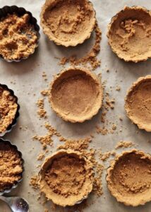 Fond de tarte vegan sans gluten aux biscuits type Graham - Verse le mélange de miettes dans le moule à tarte ou à tartelette, puis tasse-le uniformément avec le dos d’une cuillère ou un verre à fond plat.
