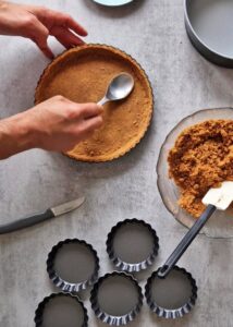 Fond de tarte vegan sans gluten aux biscuits type Graham - Presse le mélange du centre vers les bords pour que la croûte soit bien compacte et uniforme.