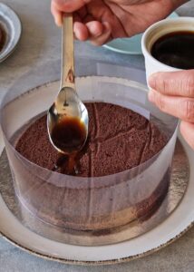 Gâteau à la courge sans gluten à 3 couches - Couche de génoise au chocolat: pose le premier disque de génoise au chocolat au fond, puis imbibe-le de sirop de café.