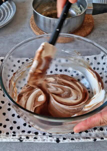 Gâteau à la courge sans gluten à 3 couches - Mélange: mélange le mélange café-crème tiède et le chocolat fondu tiède. Incorpore délicatement la crème fouettée jusqu’à obtenir une mousse à la texture légèrement liquide. Réserve et garde dans un endroit chaud pour le montage du gâteau.