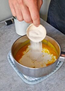 Gâteau au chocolat vegan sans gluten à la mangue - Mélange la purée de mangue, la poudre d’agar-agar, la crème entière et le jus de citron dans une petite casserole. Fouette sans arrêt en portant rapidement à ébullition. Couvre et garde dans un endroit chaud pour éviter que le mélange ne caille.