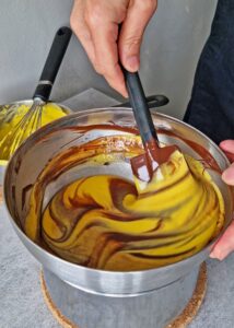 Gâteau au chocolat vegan sans gluten à la mangue - Quand le gâteau est assez ferme, saupoudre le dessus de cacao en poudre. Retire délicatement le cercle à gâteau. Décolle doucement la bande de rhodoïd pour révéler les côtés du gâteau.