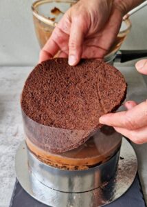 Gâteau au chocolat vegan sans gluten à la mangue - Continue en alternant les couches de biscuit au chocolat et de mousse mangue-chocolat. Chaque couche de mousse doit avoir approximativement la même épaisseur, en gardant une hauteur régulière pour chaque couche.