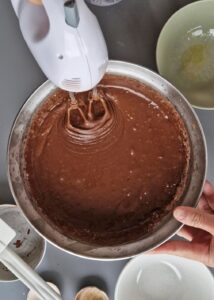 Gâteau au chocolat vegan sans gluten à la mangue - Mélange la préparation liquide avec les ingrédients secs en fouettant jusqu’à obtenir une texture lisse.