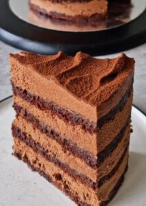 Gâteau au chocolat vegan sans gluten à la mangue - Le gâteau fini doit mesurer environ 16 cm de haut, avec les couches alternées visibles sur les côtés. Coupe avec un couteau chaud et sers.