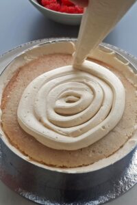 Gâteau aux fraises sans gluten - Étale une couche de crème mousseline sur le biscuit.