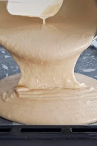 Gâteau aux fraises sans gluten - Prépare une plaque de cuisson avec du papier sulfurisé, puis verse la pâte dedans.