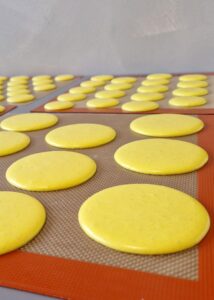 Gâteau macaron mangue framboise (sans gluten) - Poche la pâte en disques d’environ 9 cm de diamètre sur une plaque recouverte d’un tapis en silicone ou de papier cuisson.