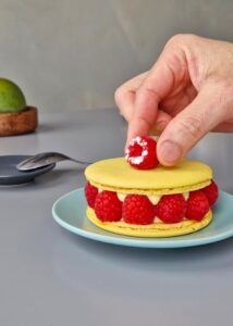 Gâteau macaron mangue framboise (sans gluten) - Dépose ensuite une framboise entière sur le dessus pour décorer avant de servir.