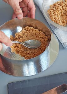 Gâteau mangue passion (sans gluten) - Tasse le mélange de miettes au fond d’un moule à charnière rond de 20 cm ou d’un cercle à gâteau, chemisé d’une bande d’acétate ou de papier cuisson. Mets au réfrigérateur pour que ça prenne pendant que tu prépares la garniture.