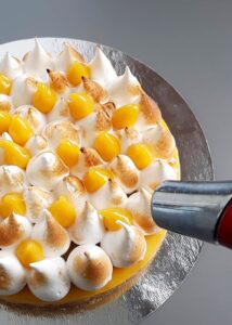 Gâteau mangue passion (sans gluten) - Brûle légèrement la meringue au chalumeau de cuisine, pour lui donner un aspect caramélisé appétissant.