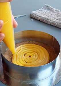 Gâteau mangue passion (sans gluten) - Étale la garniture froide à la crème mangue-fruit de la passion sur la base de biscuits préparée. Répartis uniformément avec une cuillère ou une spatule pour aplanir la surface. Garde au réfrigérateur pendant que tu fais la meringue vegan. Réserve 50-90 g de la crème mangue pour les décorations sur le dessus.
