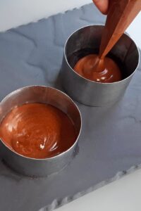 Gâteau mousse au chocolat vegan à 3 couches (sans gluten) - Poche soigneusement la mousse au chocolat au lait sur la couche de chocolat noir une fois prise. Remets au réfrigérateur pour faire prendre.