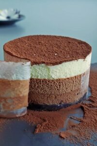 Gâteau mousse au chocolat vegan à 3 couches (sans gluten) - Couvre le dessus du gâteau de saupoudrages de cacao en poudre. Retire la feuille de rhodoïd et le cercle à gâteau avant de servir.