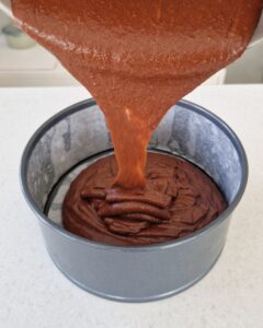 Génoise au chocolat sans gluten - Verse dans un moule à charnière de 20 cm chemisé de papier cuisson.