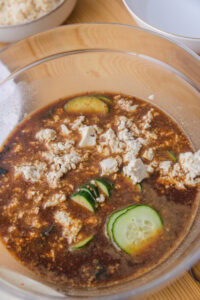 Hiyajiru - Ajouter le concombre, le myoga et le tofu émietté à la main au bouillon froid.