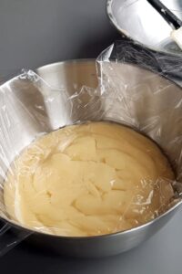 Macarons sans lactose à la crème au citron (sans gluten) - Transvase dans un récipient, couvre de film alimentaire, puis conserve au réfrigérateur pendant quelques heures jusqu’à ce que ce soit pris et assez ferme pour pocher.