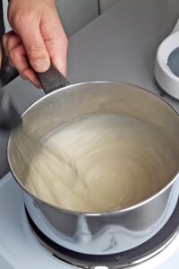 Macarons sans lactose à la crème au citron (sans gluten) - Ajoute l’eau, le zeste et le jus de citron, puis cuis à feu moyen en remuant continuellement jusqu’à ébullition et épaississement.