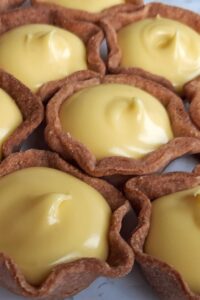 Mini tarte au citron meringuée sans gluten - Remplis les fonds de tartelettes de lemon curd et réfrigère pour faire prendre.