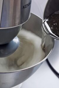 Mini tarte au citron meringuée sans gluten - Quand le sirop de sucre atteint 120°C, retire du feu et verse-le sur les blancs d’œufs en train de monter en un filet lent et régulier.