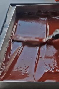 Opéra vegan à 7 couches - Étale uniformément la ganache au chocolat sur le biscuit (2e couche).