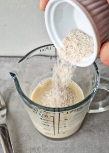 Pain levé sans gluten et sans lactose aux cranberries séchées - Mélange le lait d’avoine et le psyllium blond et laisse tremper pendant 2-3 minutes. Incorpore la levure instantanée dans le bol du robot avec le lait d’avoine, puis ajoute les œufs et le mélange au psyllium blond.