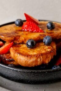 Pain perdu sans gluten - Sers le pain perdu sans gluten chaud, garni de sirop d’érable, de baies fraîches ou de fruits frais, de sucre glace ou de crème fouettée.