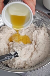 Pain sans gluten en cocotte, deux méthodes - Ajoute l’huile d’olive, puis mélange soigneusement jusqu’à ce que la pâte absorbe complètement l’huile.