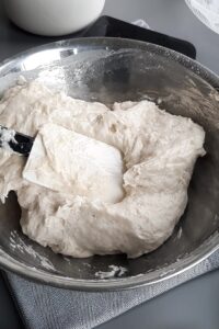 Pain sans gluten en cocotte, deux méthodes - Mélange le levain avec les ingrédients secs, ajoute le mélange de levure, puis mélange bien jusqu’à ce que la pâte se tienne.