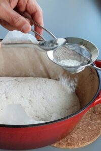 Pain sans gluten en cocotte, deux méthodes - Incise une ligne droite sur la surface de la pâte farinée avec de la farine sans gluten.