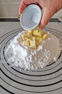 Pâte brisée sans gluten - Ajoute les cubes de beurre froid, le sel, le sucre et l’œuf.