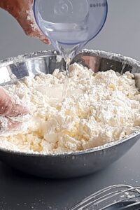 Pâte brisée vegan sans gluten sans sucre - Ajoute l’eau en 3 fois en mélangeant entre chaque ajout.