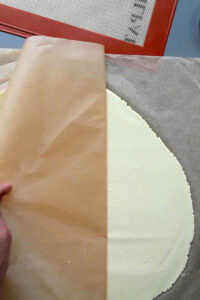 Pâte brisée vegan sans gluten sans sucre - Étale la pâte froide sur une épaisseur d’environ 3-4 mm entre des feuilles de papier cuisson pour éviter qu’elle ne colle au plan de travail.