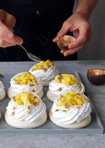 Pavlova vegan (sans gluten) - Verse un peu de jus frais de fruit de la passion avec les graines autour de la garniture.