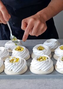Pavlova vegan (sans gluten) - Garnis la pavlova d’abord avec l’ananas mariné au basilic, puis avec la mangue.