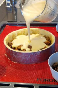 Quiche aux champignons sans gluten sans fromage - Mélange les œufs, la crème de cuisson sans lactose, le sel, la noix de muscade et le poivre dans un bol en fouettant soigneusement. Répartis uniformément les champignons et les oignons revenus sur la croûte précuite, puis verse le mélange aux œufs par-dessus.