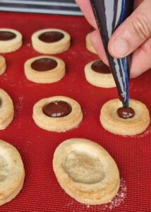 Sablés sans gluten fourrés à la ganache - Garnis le creux du dessus des biscuits avec la ganache au chocolat.