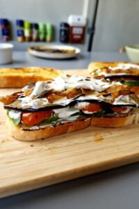 Sandwich végétarien sans gluten - Ajoute les oignons caramélisés uniformément sur les tomates.