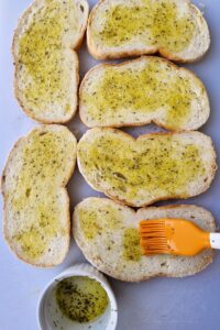 Sandwich végétarien sans gluten - Badigeonne les tranches de pain sans gluten d’huile d’olive et de basilic séché en poudre.