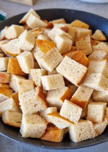 Strata sans gluten - Coupe les petits pains en petits cubes.