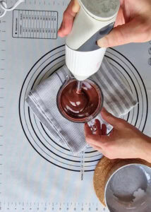 Tarte au chocolat sans gluten peu sucrée - Mixe avec un mixeur plongeant jusqu’à obtenir une texture lisse et brillante.
